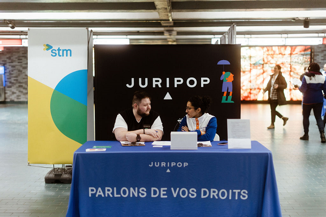 Deux personnes &agrave; un stand d'information de Juripop.